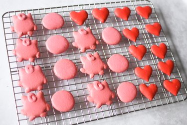 Pairs of jigglypuff and heart macarons lined up on a wire rack