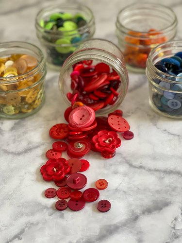 buttons organized by color stored in jars