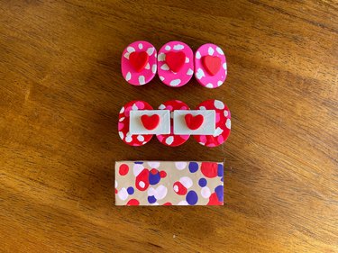 Three polymer clay barrettes in pink, red and tan colors.