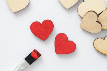 Paint wooden hearts with red paint