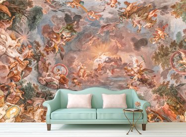 Renaissance fresco wallpaper behind blue couch