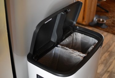 The modern trash can with its lid open revealing the two interior buckets that are removeable.