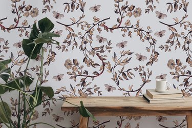Gray-toned wallpaper with branches, leaves, flowers and bees