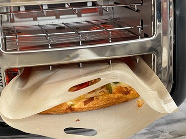 leftover pizza in a toaster bag in a toaster on its side