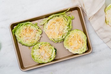 Seasoned cabbage steaks on a baking sheet