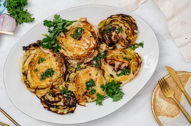 Charred cabbage with chimichurri being served on a platter