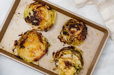 Charred cabbage steaks on baking sheet