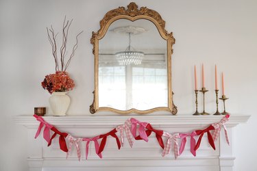 Pink and red plaid bow garland hanging from a mantel