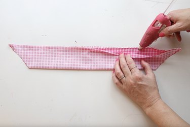 Gluing the edges of pink fabric together