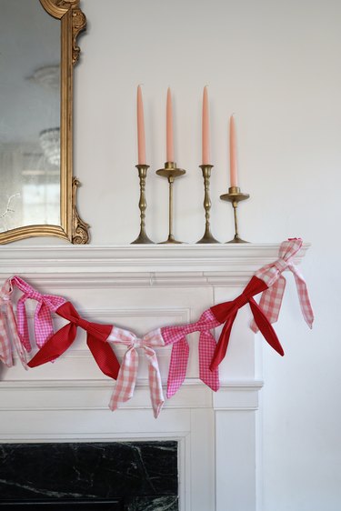 Pink and red plaid bow garland hanging from mantel