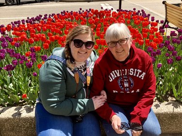 Rachel and her mom siting next to red and purple tulips