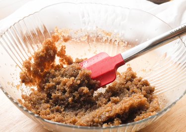 A mixing bowl with oil and brown sugar fully combined