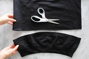 Cutting the bottom of a black sweatshirt