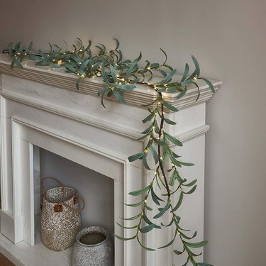 Green garland with pre-lit lights on mantel