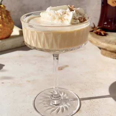 Martini glass filled with creamy liquid topped with whipped cream