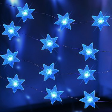 Blue Star of David string lights against a navy blue background.