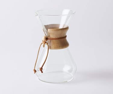 A Chemex Classic Series Pour-Over Coffeemaker with a wood collar and leather tie strap.
