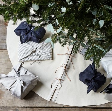 White canvas tree skirt under Christmas tree