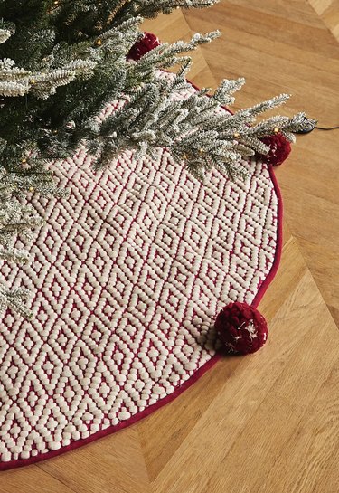 Red and white tree skirt with red pom poms