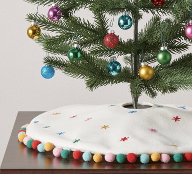 White mini Christmas tree skirt with multicolor pom pom trim