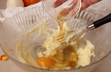 Adding egg and vanilla extract to bowl.