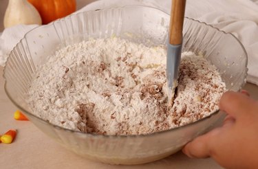 Stirring dry ingredients into mixing bowl.