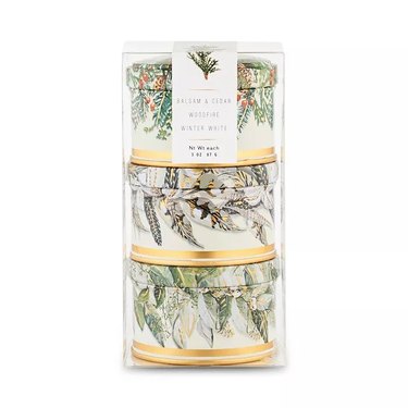 Set of three 3-oz. tin candles with festive greenery on the packaging.