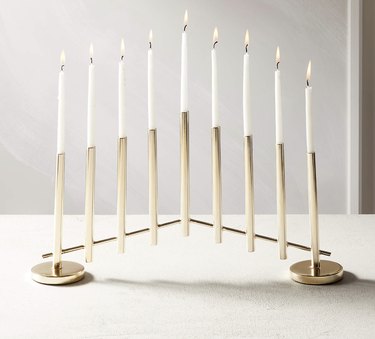 Gold modern menorah with white candles