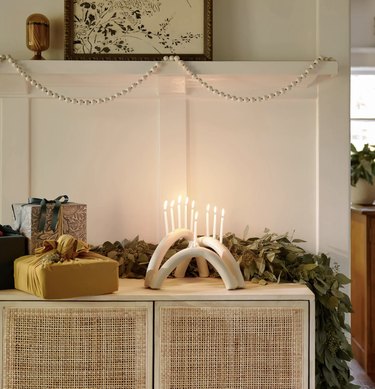 Modern white menorah on table with gifts