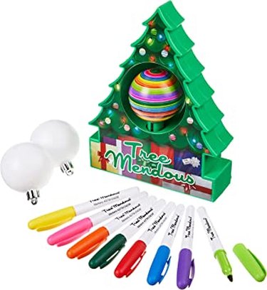 A Christmas tree-shaped container with a spinning ornament in the center and decorative pens.
