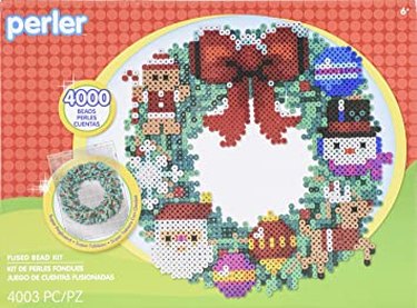 A green wreath made from flat Perler beads with a bow on top and snowman, reindeer, santa, gingerbread, and ornament appliques