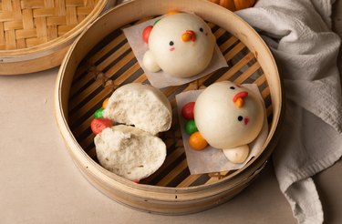 Fluffy steamed buns in a steamer basket.