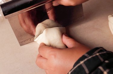 Cutting dough using bench scraper.