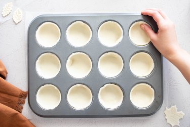 Press the pie crust into a muffin tin