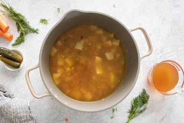 Chicken broth and vegetables in pot for pickle soup