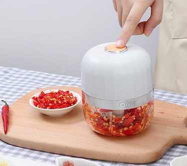 Olrid Mini Food Processor in white, chopping peppers.