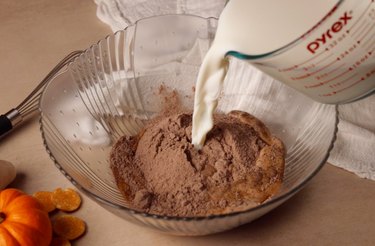 Adding milk to a bowl with instant pudding mix.