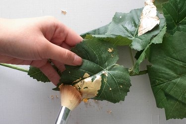 Brushing off extra gold leaf