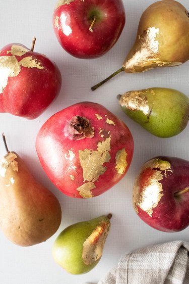 Apples, pears and pomegranate with gold leaf