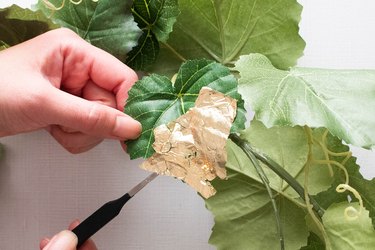 Adding gold leaf to garland