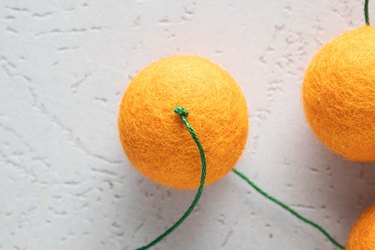 Tie a knot on the first and last wool felt ball