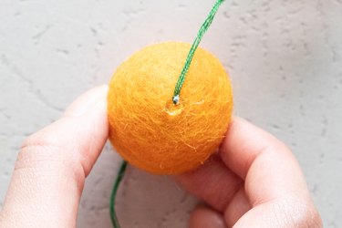 Add hot glue to each wool felt ball