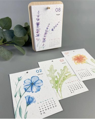 Four pages of a calendar with watercolor flowers (including lavender and a blue flower)