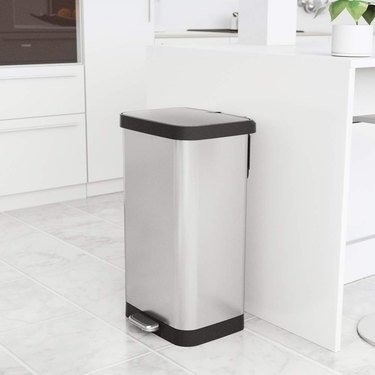 Glad 20 gallon garbage can, with stainless steel finish, shown at the end of the counter in a modern-looking white kitchen