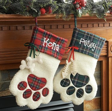 Two dog paw Christmas stockings in white, red and green