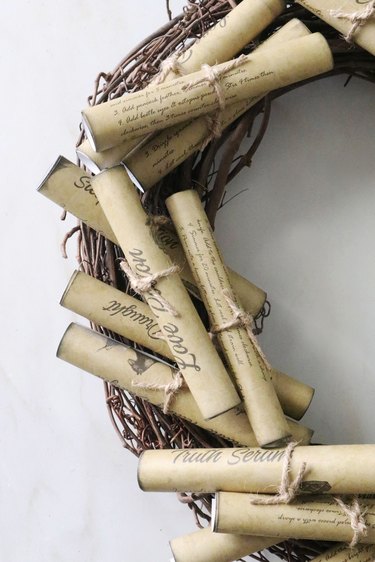 Glue potion scrolls on grapevine wreath