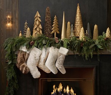 Five faux fur stockings on mantel with Christmas decor