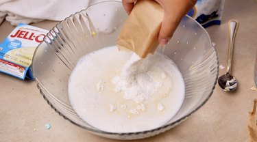 Adding instant pudding mix to milk in mixing bowl
