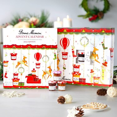 A Bonne Maman 2022 Limited Edition Advent Calendar pictured next to a trio of miniature jams.