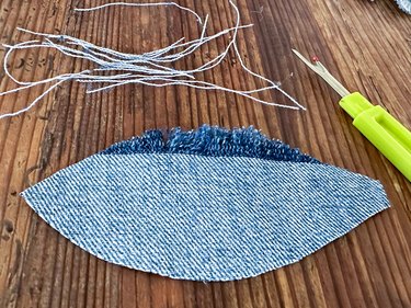 Use seam ripper to pull threads from both sides of the denim feather